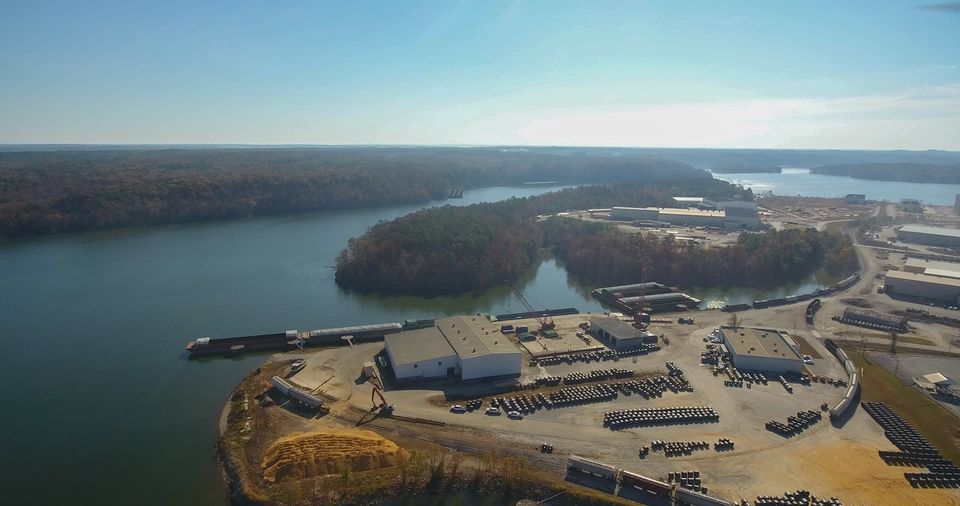 Aerial view of a timber port yard beside the water.